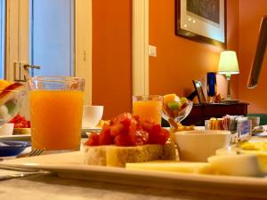 a table with a plate of food and a glass of orange juice at Villino Eleonora in Parghelia