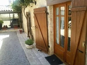 an entrance to a house with a wooden door at CHAMBRE A LA CAMPAGNE - CHARENTE in La Rochette