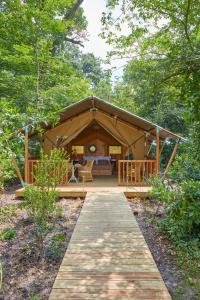 a tent in the woods with a wooden walkway at Hôtel Domaine de Raba Bordeaux Sud in Talence