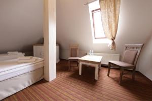 a bedroom with a bed and a table and a window at Hotel Nad Stawem in Bogacica