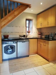 a kitchen with a washing machine and a staircase at 6 beili priory in Abergavenny