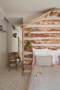 a bedroom with a wooden bed and a chair at Hôtel Domaine de Raba Bordeaux Sud in Talence