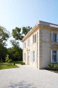 a large white house with a driveway at Hôtel Domaine de Raba Bordeaux Sud in Talence