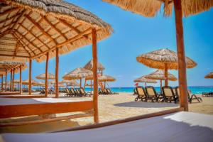 a beach with umbrellas and lounge chairs at Emporio Cancun in Cancún
