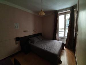 a small bedroom with a bed and a window at Hotel Anya in Paris