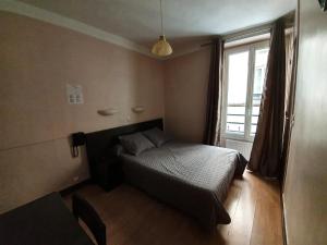 a small bedroom with a bed and a window at Hotel Anya in Paris