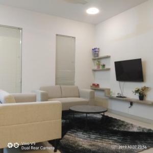 a living room with a couch and a tv at SleepRest @ The Home Shoutlink in Nagoya