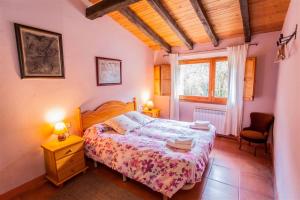 une chambre avec un lit, une chaise et une fenêtre dans l'établissement El Paller del Molí de la Plana, à Riudaura 29 autres photos