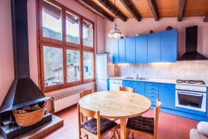 - une cuisine avec une table en bois et une cuisinière dans l'établissement El Paller del Molí de la Plana, à Riudaura