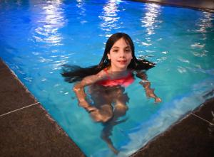 a young girl swimming in a swimming pool at In De Achtste Hemel in Schimmert