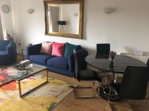 a living room with a blue couch and a table at RIVERSIDE 2 BED APARTMENT in North Woolwich