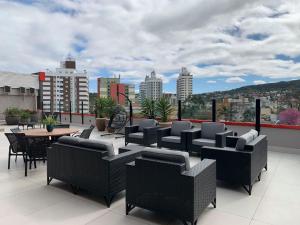 a patio with chairs and tables on a roof at Rede Andrade Criciuma in Criciúma