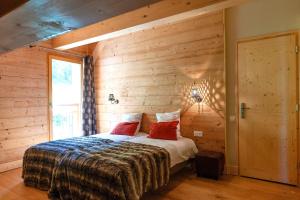um quarto com uma cama numa parede de madeira em Balcons du Bettex em Les Menuires