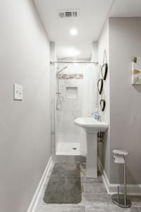 a white bathroom with a shower and a sink at Lavish Living - 8 mins from Braves Stadium w/King in Smyrna