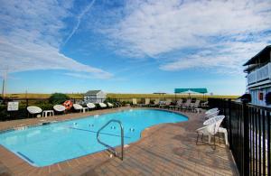 a large swimming pool with chairs and a fence at Sea Cliff House Motel in Old Orchard Beach