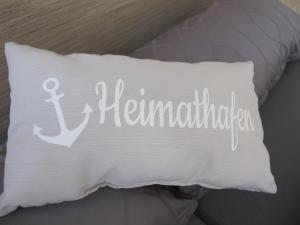 un oreiller blanc avec une ancre et une écriture dessus dans l'établissement Seestern - Ferienhaus am Quendorfer See (Nr. 5), à Schüttorf