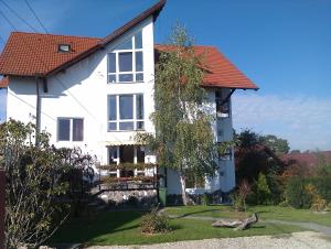 a white house with a red roof at Pensiunea Riunione in Braşov