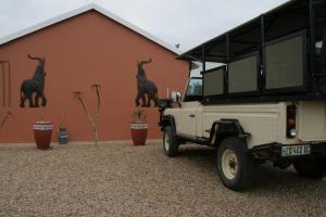une jeep garée devant un mur avec une fresque murale représentant une girafe dans l'établissement Little Sister's, à Colchester