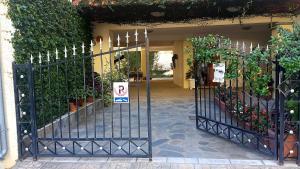 an entrance to a building with a gate with plants at Cozy Studio in Trikala Center with private Parking! in Tríkala