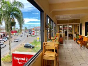 ein Restaurant mit Balkon und Straßenblick in der Unterkunft Tropical Breeze Apartments in Paramaribo
