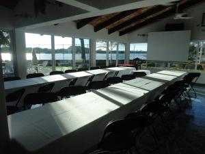 a row of tables and chairs in a room with windows at Hotel Marina San Blas in San Blas