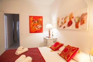 - une chambre avec un grand lit et des oreillers rouges dans l'établissement GRAN APARTAMENTO PLAZA DE ESPAÑA, à Séville