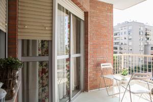 a balcony with a table and chairs and a brick building at GRAN APARTAMENTO PLAZA DE ESPAÑA in Seville