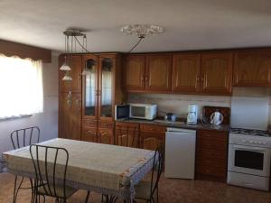 a kitchen with wooden cabinets and a table with chairs at Casa Caetano in Souto da Carpalhosa