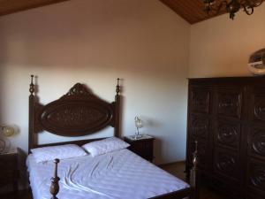 a bedroom with a bed with a wooden headboard at Casa Caetano in Souto da Carpalhosa