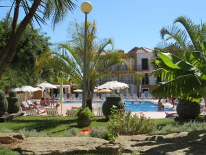 a resort with a swimming pool and palm trees at Casa Morgado in Tavira