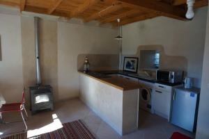 a kitchen with a counter and a stove in a room at Joli gîte en Ariège avec vue in Buzan