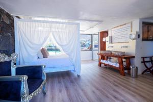 a bedroom with a bed with a window and a table at Hotel Puntagrande in Frontera