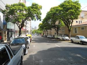 une rue avec des voitures garées sur le côté de la route dans l'établissement Pousada Danza - Centro, à Poços de Caldas