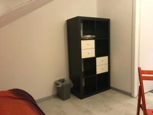 a black book shelf in the corner of a room at Cozy Room in Ludwigsburg in Ludwigsburg