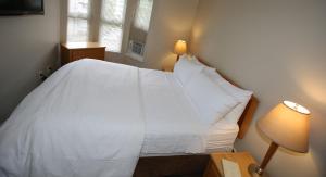a bedroom with a white bedspread and white pillows at Times Square Suites Hotel in Vancouver