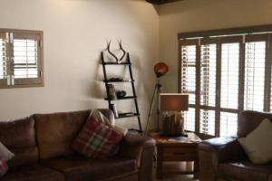 a living room with a couch and a table with a lamp at Luvivane Luxury Villa in Marloth Park