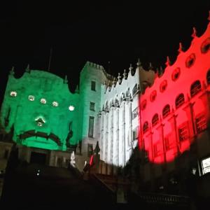a building is lit up in green and red at Loft en Casa Jasso! in Guanajuato