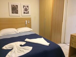 1 dormitorio con 1 cama y 2 toallas blancas en Flat no Beach Class Muro Alto, en Porto de Galinhas