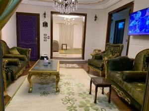 a living room with green couches and a coffee table at mody appartment at alexandria in Alexandria