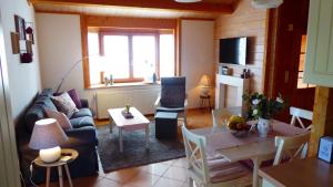 a living room with a couch and a table at Blockhuus Thüle in Garrel