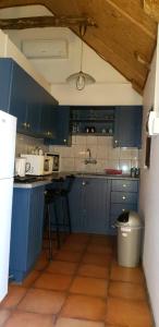 a blue kitchen with blue cabinets and a sink at Nooitgedacht Self Catering CC in Okahandja
