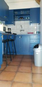 a blue kitchen with blue cabinets and a table at Nooitgedacht Self Catering CC in Okahandja