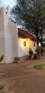 un edificio de ladrillo blanco con un banco delante de él en Nooitgedacht Self Catering CC, en Okahandja