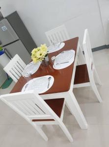 ブトゥアンにあるDiodeth's Holiday Apartmentsの木製テーブル(白い椅子2脚、花付)
