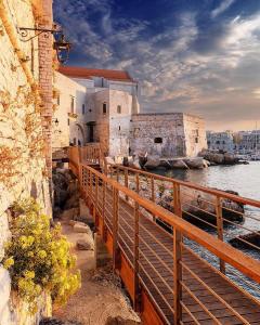a bridge over a body of water next to a building at Palazzo Framarino dei Malatesta - Noble Floor - XIV Century in Giovinazzo