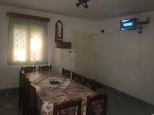 a dining room with a table and chairs and a television at Pataki Kulcsosház in Izvoare