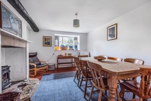 a dining room with a table and chairs and a fireplace at Church Farm Cottage in Cheltenham