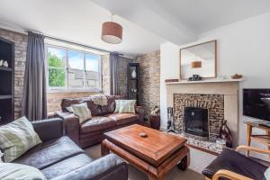 a living room with a couch and a fireplace at Church Farm Cottage in Cheltenham
