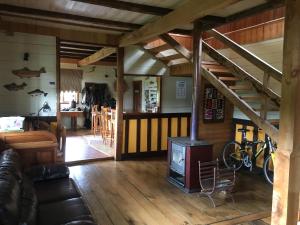 sala de estar con estufa de leña y escalera en La Casona Puelo Lodge, en Cochamó