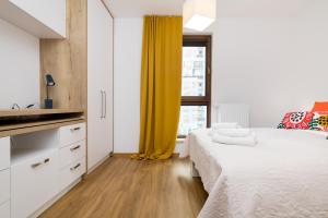 - une chambre avec un lit et un rideau jaune dans l'établissement Wola Business Apartments, à Varsovie